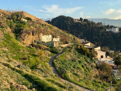 CTH Granada hotel nestled in Armilla hillside with lush green landscape and snow-capped mountains