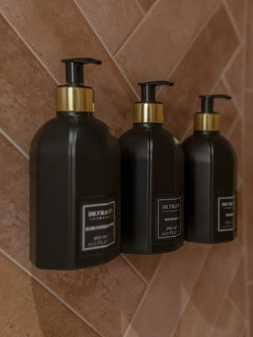 Three black Dr. Vranjes bathroom amenity bottles with gold pumps at YOUnique Boutique Rooms Milano