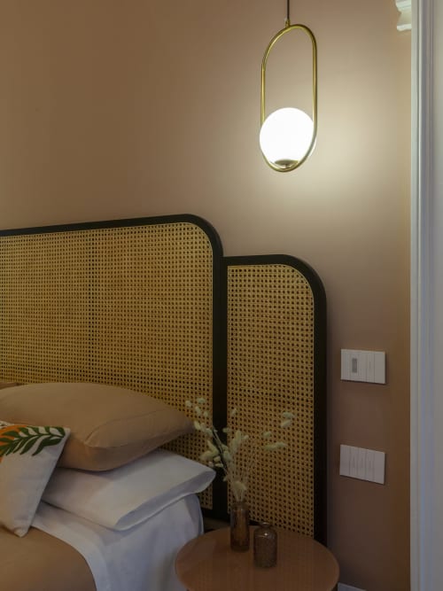 Modern bedroom at YOUnique Boutique Rooms Milano with rattan headboard, pendant lighting, and contemporary decor