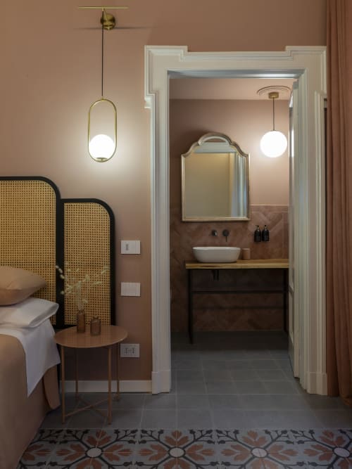 Camera e bagno in stile vintage presso YOUnique Boutique Rooms Milano, con lampadari retrò e elegante lavabo