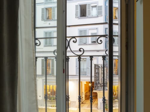 Balcony view of Milan courtyard from Moon River room at YOUnique Boutique Rooms, featuring ornate iron railings and