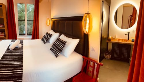 Chambre moderne au Gîte Le Moulin du Guy à Chanverrie avec literie blanche, luminaires suspendus et accents rouges