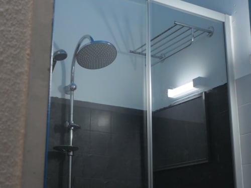 Modern shower enclosure at Studio Face Marina with rainfall showerhead, handheld spray, and towel rack in Saint-François,