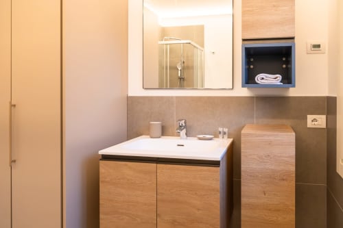Bagno moderno nell'appartamento di Treviso con mobile legno, specchiera e nicchia blu per asciugamani