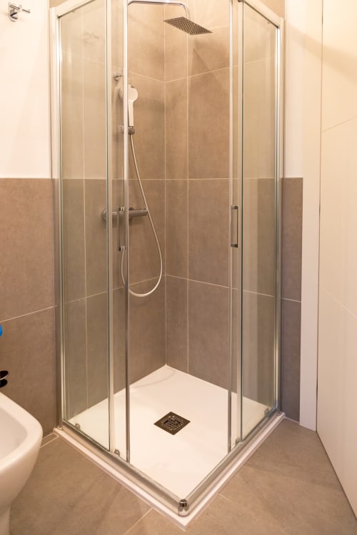 Moderna cabina doccia in vetro con soffione pioggia e doccetta manuale nella suite Ca' Borsa IV di Treviso Stays, Treviso