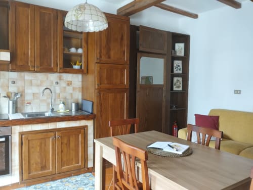 Accogliente zona cucina-pranzo in Casina Bella Vista, Campagnano di Roma, con rivestimento in piastrelle color crema e posti a sedere confortevoli