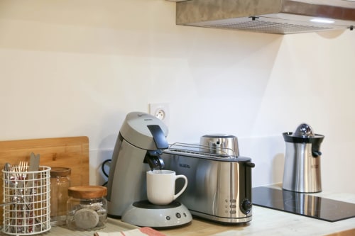 Kitchen counter with coffee maker, toaster, and kettle in Wellkhome Bordeaux apartment