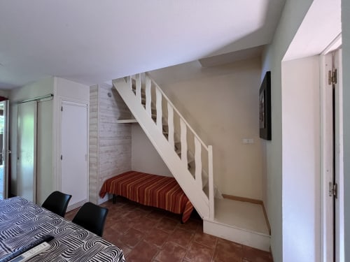 Luminosa camera studio al Le Maquis Plage con soppalco, letto rigato e scala bianca moderna a Poggio-Mezzana