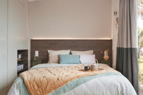 Chambre moderne du Mobil-Home Bambou au Maquis Plage, Poggio-Mezzana, avec lit queen-size et accents turquoise
