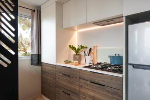 Cuisine moderne du Mobil-Home Bambou au Maquis Plage, Poggio-Mezzana avec cuisinière à gaz et éclairage ambiant
