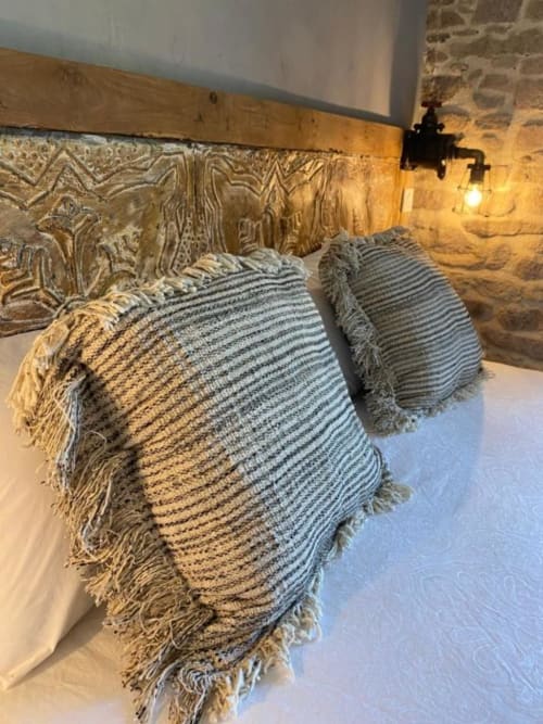 Coussins rayés à franges sur le lit de la chambre Java au Moulin du Guy à Chanverrie
