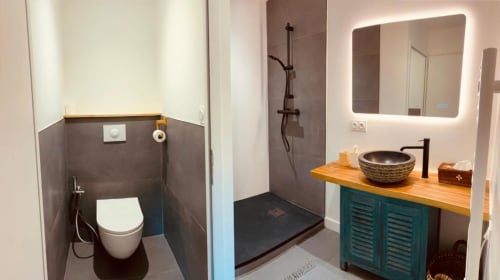 Salle de bain moderne à La Chambre Java du Moulin du Guy, avec vasque bleu canard, lavabo suspendu et douche à l'italienne