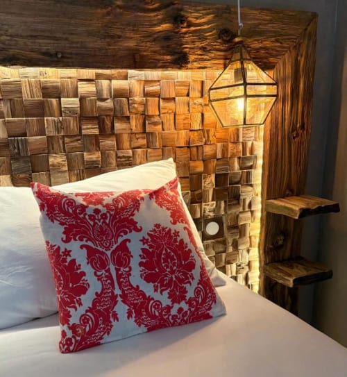 Tête de lit rustique en bois avec coussin damassé rouge dans la Chambre du Moulin du Moulin du Guy, Chanverrie France