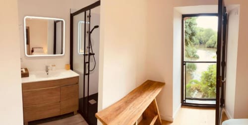 Salle de bain moderne avec vanité en bois, miroir et douche au Moulin du Guy B&B à Chanverrie, France, vue rivière