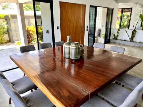 Comedor moderno con mesa de madera oscura y sillas grises en la cabaña Casa Tsuki en Puerto Escondido, México