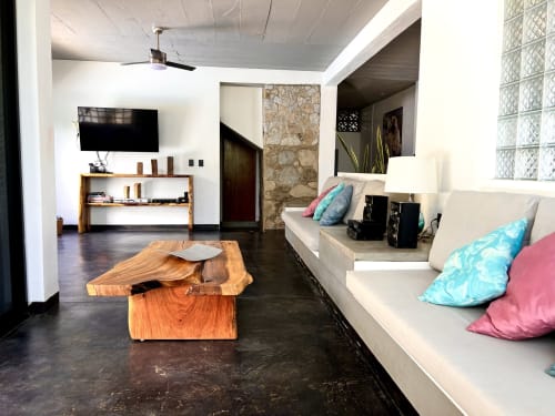 Sala de estar moderna de Casa Tsuki en Puerto Escondido con mesa de madera, asientos blancos, televisor y cojines coloridos