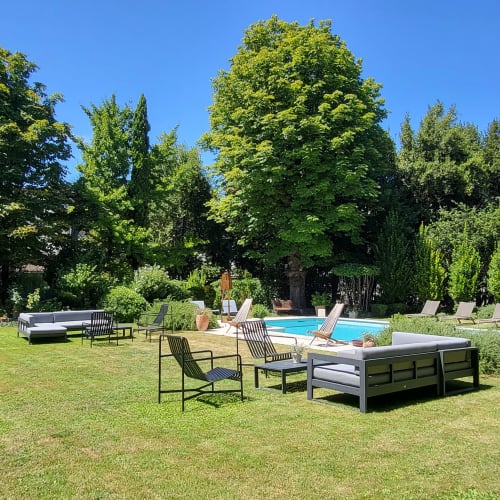 Jardin du Logis des Tourelles avec transats, espaces de détente et piscine entourés de verdure à Cognac