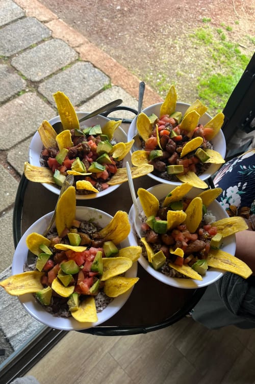 Four plates of traditional Costa Rican casados with fried plantain chips, ground beef, tomatoes, and peppers at Chalets