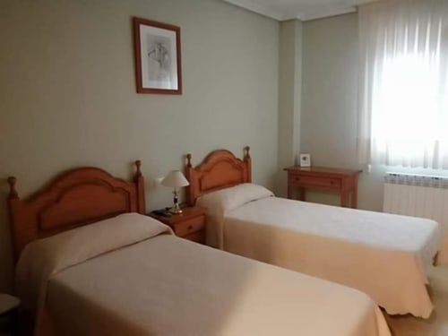 Luminosa habitación doble en Pensión San Vicente con camas de madera, escritorio y luz natural en San Vicente de la Sonsierra