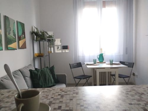 Luminoso appartamento moderno con sala da pranzo, divano, piante e vista sul giardino vicino Roma