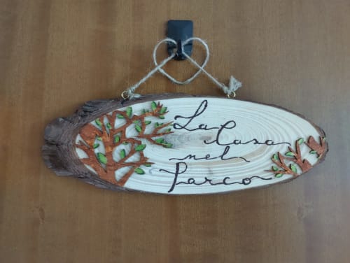 Targhetta in legno con alberi decorativi e testo italiano 'La Casa nel Parco' nell'appartamento di Campagnano di Roma