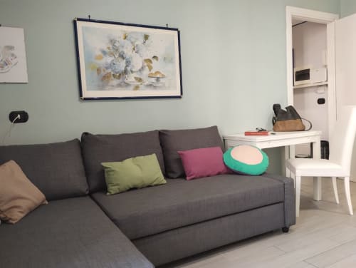 Divano grigio moderno con cuscini colorati nel salotto di un appartamento a Campagnano di Roma