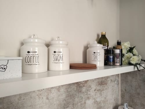 Scaffale minimalista del bagno con barattoli per caffè e zucchero, vasetto di sale e articoli da toilette in appartamento romano