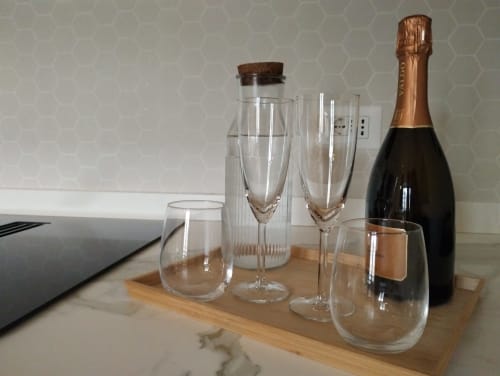 Elegante flute di champagne e bicchieri di vino su vassoio di legno con bottiglia a Dimora S. Bartolomeo a Roma
