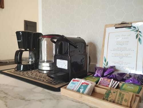 Angolo caffè con macchina da caffè, selezione di tè e menu dei vini nell'appartamento di Campagnano di Roma