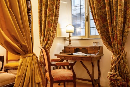 Scrivania elegante con tende ornate e lampada da tavolo nella residenza Sinibaldi, Roma