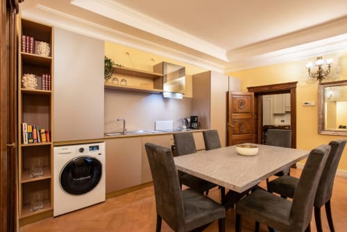 Zona living moderna con angolo cottura, lavatrice e vista sulla città a Roma