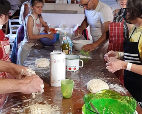 Ospiti preparano cibo insieme durante una lezione di cucina presso la Corte delle Giuggiole B&B a Cologna Veneta, Italia