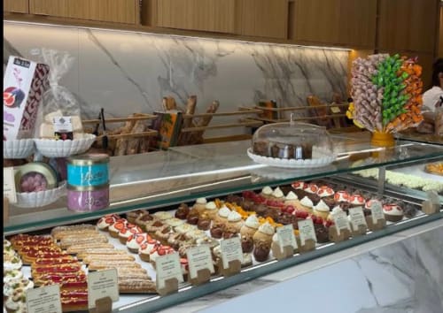 Alma Rossa bakery display case in Lecci with pastries, cakes, and desserts behind glass counter