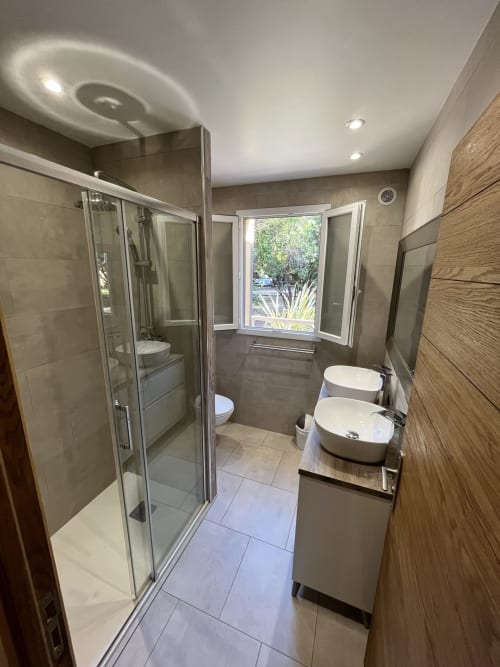 Modern bathroom at Le Maquis Plage hotel with dual sinks, walk-in shower, and garden view in Poggio-Mezzana