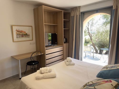 Chambre lumineuse à Villa Marine, Centuri avec vue sur mer, armoire en bois, bureau et accès à la terrasse