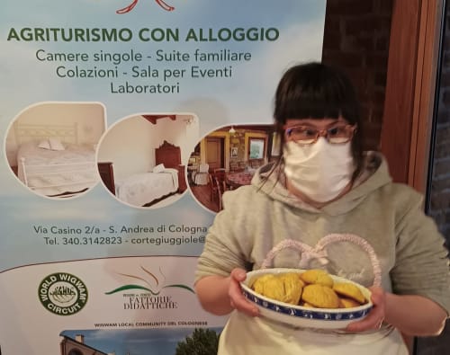 Donna che tiene pasticcini locali presso l'agriturismo Corte delle Giuggiole a Cologna Veneta, Veneto