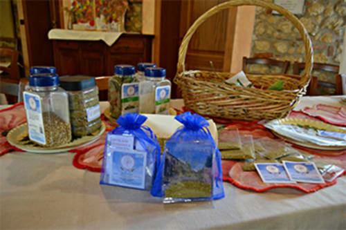 Esposizione del regalo di benvenuto Corte delle Giuggiole: sacchetti in organza blu e vasetti di vetro con erbe locali sul tavolo da pranzo, Cologna