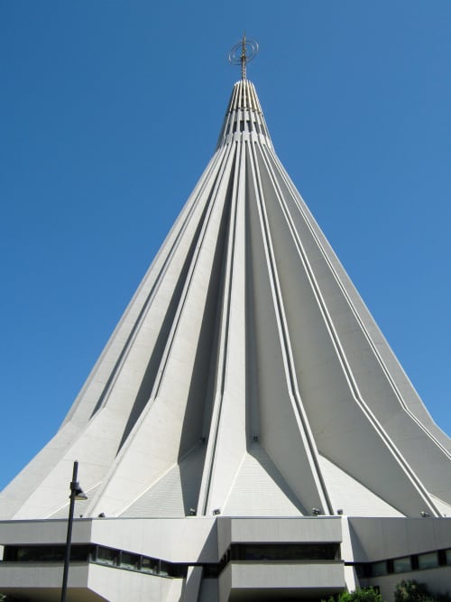Moderno campanile bianco a forma conica della chiesa contro il cielo azzurro a Fontane Bianche, Sicilia