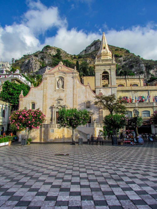 Chiesa di San Salvatore a Taormina con colline rocciose e fiori in fiore in Sicilia, Italia
