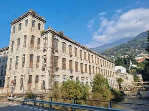 Antico edificio in pietra con torre che si affaccia sul Lago di Como a Bellano, Italia