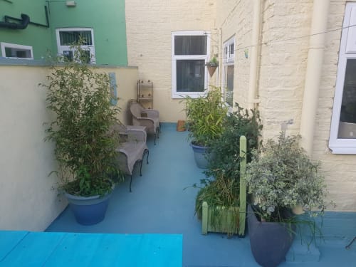 Cozy patio courtyard at Jane's B&B villa in Guisborough with blue floor, potted plants, and seating area