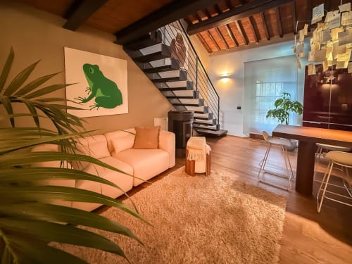 Loft living di Cognaia ad Arezzo con divano pesca, arte geometrica di rana, scale in legno e illuminazione calda