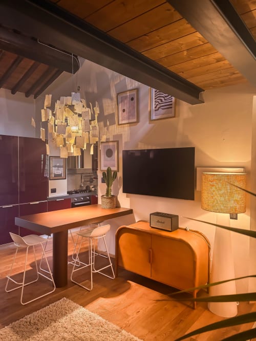 Moderno loft Cognaia ad Arezzo con living open-plan, cucina, divano arancione, TV, soffitto in legno e design contemporaneo