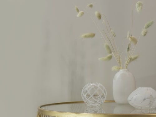 Minimalist white vase with dried pampas grass on gold mirror table in Milano boutique hotel room