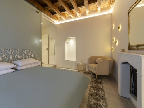 Camera romantica presso YOUnique Boutique Rooms Milano con testata ornamentale, travi in legno a vista, bagno ensuite moderno ed elegante