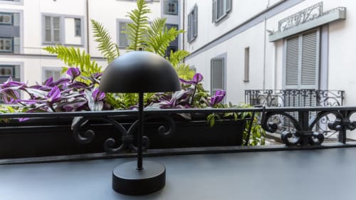 Black dome lamp on Milano balcony with purple flowers and fern plants at YOUnique Boutique Rooms