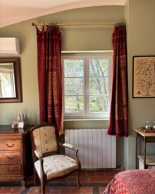 Adrien's room at Domaine Du Commandeur with elegant furnishings, red damask curtains, garden view windows, and period chair