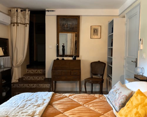 Elegant bedroom at Domaine Du Commandeur in Mondragon with queen bed, wooden desk, mirror, and classic furnishings