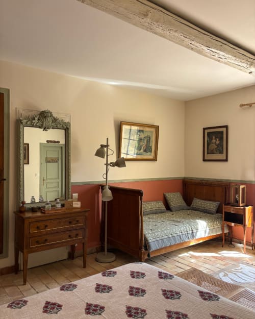 Isadora's room at Domaine Du Commandeur, Mondragon: period bedroom with wooden furniture, red-painted walls, framed artwork,