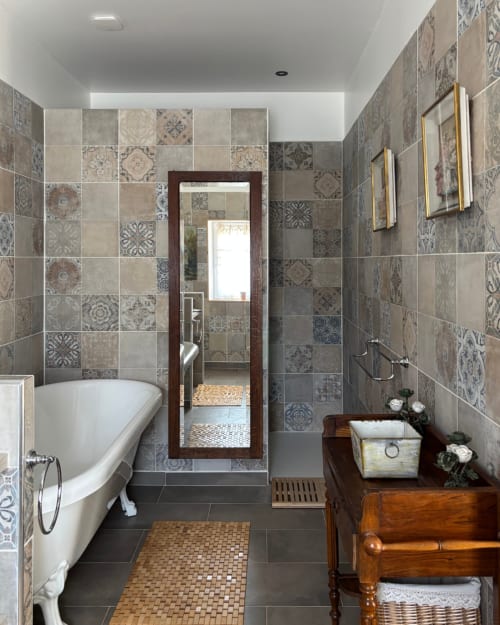 Elegant bathroom in Isadora's room at Domaine Du Commandeur, Mondragon, with patterned tile walls, clawfoot tub, and vintage